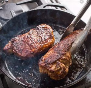 CastIronWSteakAndTongs Cast iron with steak
